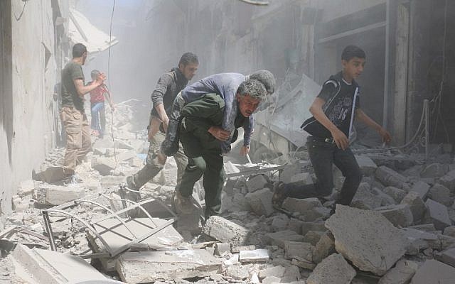 Syrians evacuate an injured man amid the rubble of destroyed buildings following a reported air strike on the rebel-held neighborhood of Al-Qatarji, in the northern Syrian city of Aleppo, on April 29, 2016. AFP/ AMEER ALHALBI)