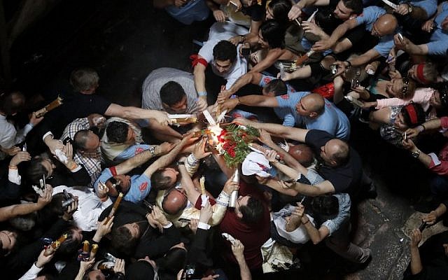 Christian Orthodox worshippers hold up candles lit from the "Holy Fire" as thousands gather in the Church of the Holy Sepulchre in Jerusalem's Old City, on April 30, 2016, during the Orthodox Easter ceremonies.(AFP PHOTO / THOMAS COEX)