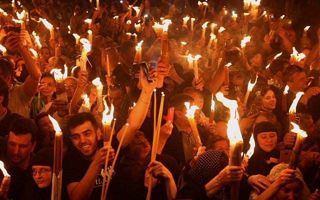 Christian Orthodox worshippers hold candles lit from the "Holy Fire" as thousands gather in the Church of the Holy Sepulchre in Jerusalem's Old City on April 30, 2016 during the Orthodox Easter ceremony.(AFP PHOTO/GALI TIBBON)