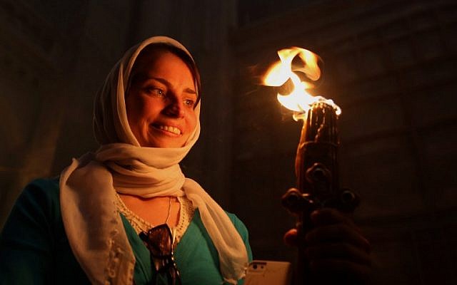 A Christian Orthodox worshipper holds candles lit from the "Holy Fire" as thousands gather in the Church of the Holy Sepulchre in Jerusalem's Old City on April 30, 2016 during the Orthodox Easter ceremony.(AFP PHOTO / GALI TIBBON)