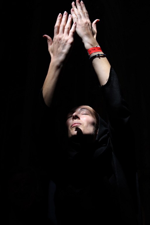 A Christian Orthodox pilgrim from Abkhazia raises her hands as a ray of light comes through during the "Holy Fire" Orthodox Easter procession in the Church of the Holy Sepulchre, in Jerusalem's Old City on April 30, 2016. (AFP PHOTO / GALI TIBBON)