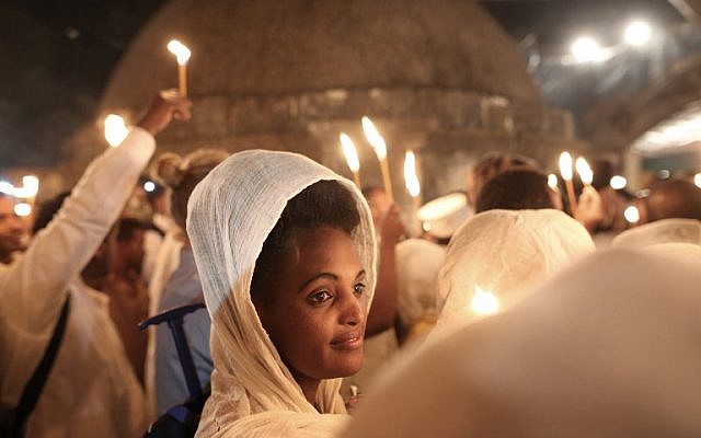 Ethiopian Christian pilgrims hold candles during an Ethiopian Orthodox ceremony of the "Holy Fire" at the Dir Al-Sultan Church held on the roof of the Holy Sepulcher in Jerusalem's Old City on April 30, 2016. ( AFP PHOTO / MENAHEM KAHANA)