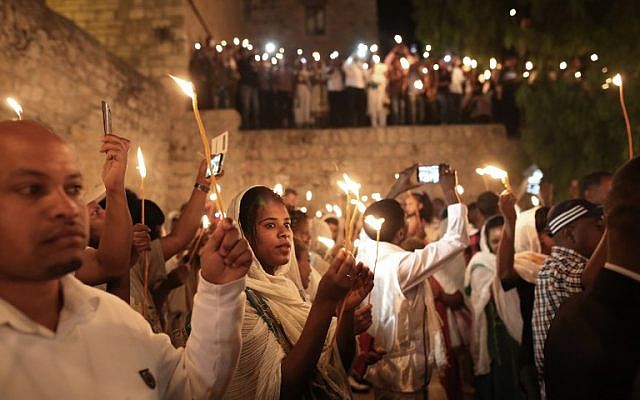 Ethiopian Christian pilgrims hold candles during an Ethiopian Orthodox ceremony of the "Holy Fire" at the Dir Al-Sultan Church held on the roof of the Holy Sepulcher in Jerusalem's Old City on April 30, 2016.(AFP PHOTO / MENAHEM KAHANA)