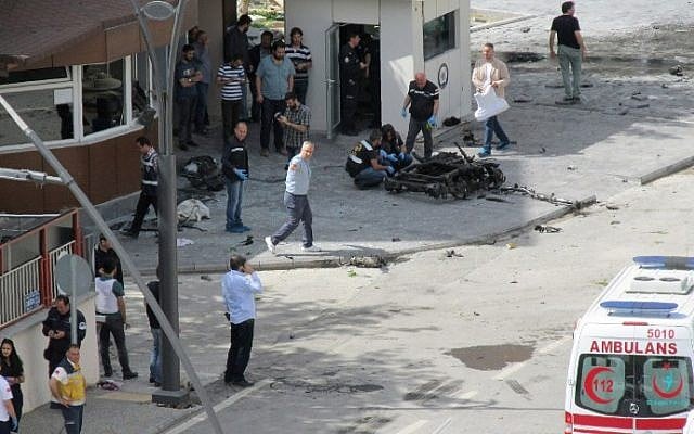 Police officers look at a piece of debris outside the police headquarters in the southeastern Turkish city of Gaziantep on May 1, 2016. (AFP/Ilhas News Agency)