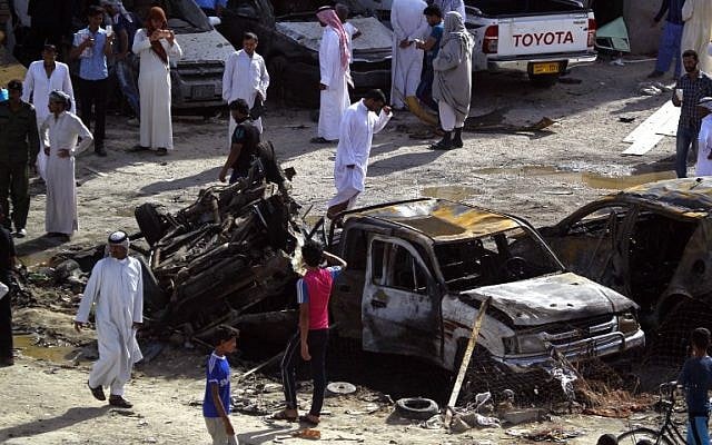 Iraqis look at the damage following a twin suicide bombing attack, claimed by the Islamic State group, in the southern Iraqi city of Samawah, May 1, 2016. (AFP Photo/Haidar Hamdani)