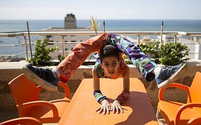 Palestinian teenager Mohammed al-Sheikh, 12, shows his skills on a table in Gaza City on April 28, 2016. / AFP PHOTO / MAHMUD HAMS
