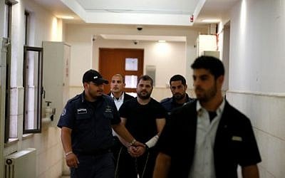 Yosef Haim Ben David (C), the ringleader in the killing of Palestinian teenager Muhammed Abu Khdeir in 2014, is escorted by Israeli policemen at the Jerusalem District Court on May 3, 2016 (AFP PHOTO / AHMAD GHARABLI)