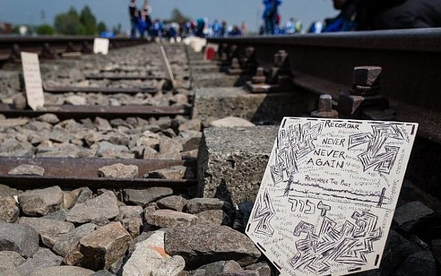 A wooden plaque placed by participants of the annual "March of the Living" is seen on the railtracks of the former Auschwitz-Birkenau Nazi death camp in Brzezinka (Birkenau) near Oswiecim (Auschwitz), Poland, on May 5, 2016. (AFP PHOTO / WOJTEK RADWANSKI)