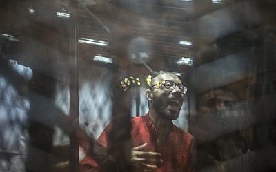Ahmed Abdel-Aaty, the former head of Egypt's ousted Islamist president's office, wearing a red uniform, stands behind the defendant's bars during his trial at the police academy in Cairo on May 7, 2016. (AFP PHOTO/KHALED DESOUKI)