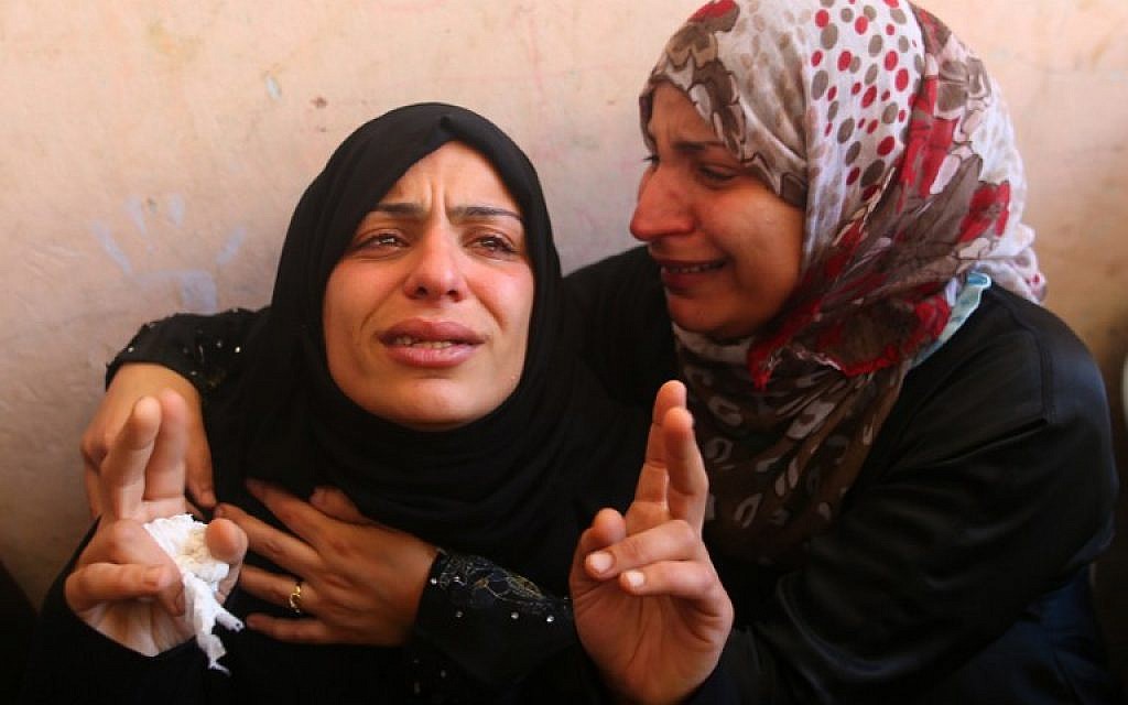 The mother of the Abu Hindi family (L) mourns during the funeral of three of her sons who died in a fire caused by a candle at the family home, at the al-Shati refugee camp in Gaza City on May 7, 2016. (AFP PHOTO/MOHAMMED ABED)