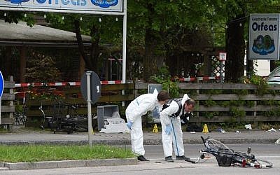 Forensic experts of the police are seen working in front of the train station in Grafing near Munich, southern Germany, where a man killed one person and wounded three others in a knife attack on May 10, 2016. (AFP PHOTO / Christof Stache)