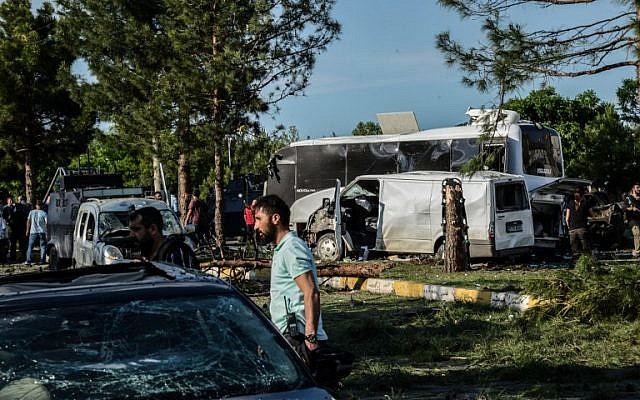 Damaged vehicles are seen as Turkish plain clothes police officers investigate the site where a bomb exploded, Diyarbakir, Turkey, May 10, 2016. (AFP/Ilyas Akengin)