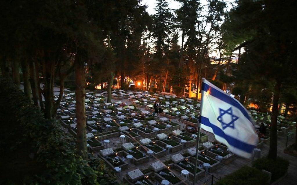 Israeli women visit the grave of a loved one at the Mount Herzl military cemetery in Jerusalem at the start of Remembrance Day, commemorating fallen Israeli soldiers on May 10, 2016. (AFP PHOTO / MENAHEM KAHANA)