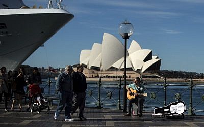 Illustrative: A man plays a song on a guitar on the Sydney Harbor in front of the iconic Opera House on May 11, 2016.  (AFP/SAEED KHAN)
