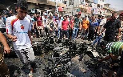 Iraqis check the site of a car bomb attack in Sadr City, a Shiite area north of the capital Baghdad, May 11, 2016.  (AFP/AHMAD AL-RUBAYE)