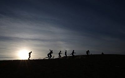 Palestinian children play on a sand dune at the Rafah refugee camp, in the southern Gaza Strip, May 11, 2016. (AFP/MOHAMMED ABED)