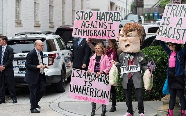 Protesters against US Republican presidential candidate Donald Trump hold signs outside the Republican National Committee (RNC) headquarters on Capitol Hill in Washington, DC, on May 12, 2016 where Trump was meeting with House Speaker Paul Ryan. AFP PHOTO / Nicholas Kamm)
