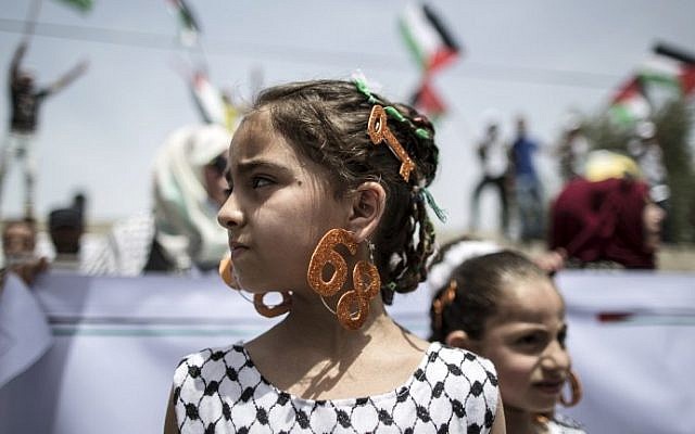 A Palestinian girl wears earrings bearing the number "68" and a hair slide in the shape of a key on May 15, 2016 in Gaza city during a rally to commemorate the "Nakba." (AFP PHOTO / MAHMUD HAMS)