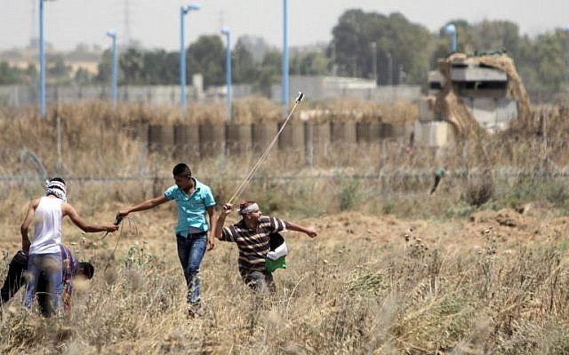 Palestinian youth hurl rocks at Israeli military during clashes at the border east of Gaza city on May 15, 2016, on the 68th anniversary of the "Nakba." (AFP/ MAHMUD HAMS)