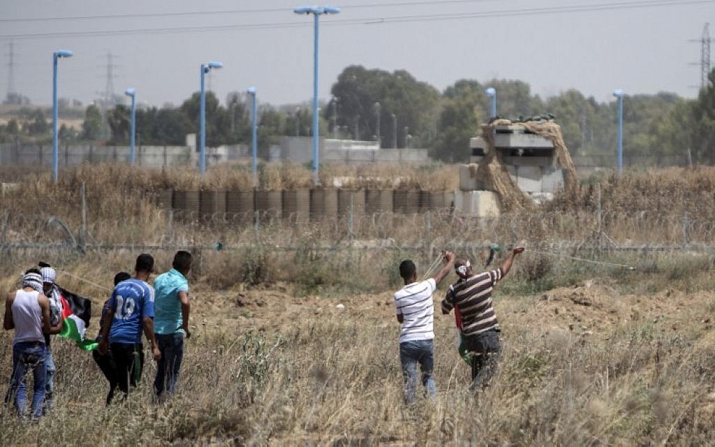 Palestinian youth hurl rocks at Israeli military during clashes at the border east of Gaza city on May 15, 2016, on the 68th anniversary of the "Nakba." (AFP/MAHMUD HAMS)