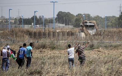 Palestinian youth hurl rocks at Israeli military during clashes at the border east of Gaza City on May 15, 2016, on the 68th anniversary of the "Nakba." (AFP/MAHMUD HAMS) Palestinian youth hurl rocks at Israeli military during clashes at the border east of Gaza City on May 15, 2016, on the 68th anniversary of the "Nakba." (AFP/MAHMUD HAMS)