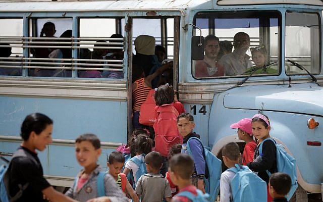 Syrian refugee children prepare to board a school bus at an unofficial refugee camp in Lebanon's town of Bar Elias in the Bekaa Valley on May 13, 2016. (AFP PHOTO / JOSEPH EID)