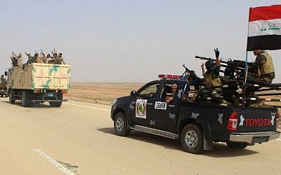 Iraqi government forces and local tribal fighters drive on the highway between Ramadi and Rutba as they take part in an operation to retake Rutba from the Islamic State jihadist group on May 16, 2016. (AFP Photo/Moadh Al-Dulaimi)
