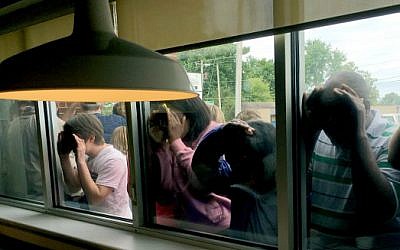 People peer through the window to catch a glimpse of Democratic presidential candidate Hillary Clinton during a campaign rally at the La Gala restaurant May 16, 2016, in Bowling Green, Kentucky. (Michael Mathes/AFP)