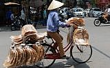 Illustrative. A street vendor sells rice crackers from her bicycle in downtown Hanoi on May 17, 2016. (AFP PHOTO/HOANG DINH NAM)