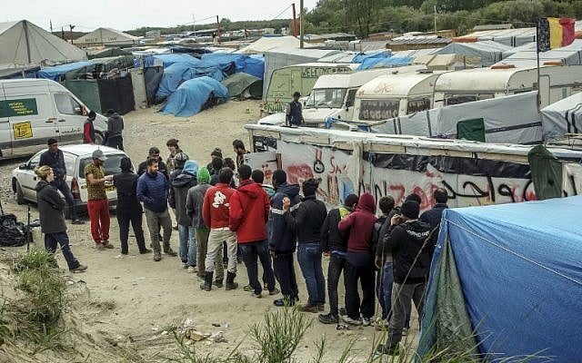 Migrants stand in line to receive food from an organization inside the 'Jungle' slum in Calais on May 18, 2016. (AFP PHOTO/PHILIPPE HUGUEN)