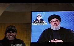 Hezbollah's leader Hassan Nasrallah is seen on a giant screen broadcasting his speech on May 20, 2016 in a southern suburb of the capital Beirut during a memorial ceremony to mark a week since slain Hezbollah commander Mustafa Badreddine (portrait) was killed in an artillery attack near Damascus. (Joseph Eid/AFP)