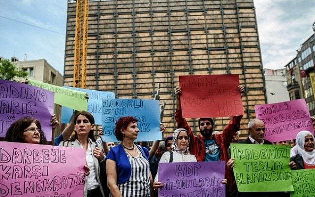 Supporters of People's Democratic Party (HDP) hold placards reading "We do not accept palace's coup - Democratic resists agianst palace's coup" on May 20, 2016 during a protest at the Istiklal avenue in Istanbul. (AFP PHOTO / OZAN KOSE)