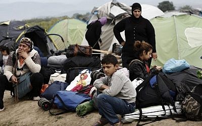 A refugee family sits in front of their tent as they wait to be transferred to reception centres, during an evacuation operation by Greek police forces of the makeshift camp at the Greek-Macedonian border, near the village of Idomeni, on May 24, 2016. (AFP PHOTO / POOL / YANNIS KOLESIDIS)