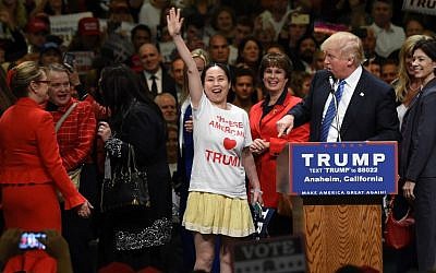 A supporter wearing a "Chinese Americans Love Trump" shirt takes the stage with other female Trump supporters at a campaign rally by the presumptive Republican presidential candidate, May 25, 2016 in Anaheim, California. (AFP/ ROBYN BECK)