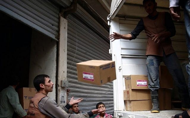 Members of the Syrian Arab Red Crescent deliver aid to the besieged rebel bastion of Douma, a flashpoint near the Syrian capital Damascus on May 26, 2016. (AFP/Abd Doumany) Members of the Syrian Arab Red Crescent deliver aid to the besieged rebel bastion of Douma, a flashpoint near the Syrian capital Damascus on May 26, 2016. (AFP/Abd Doumany)