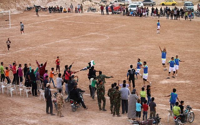 Syrians cheer during a friendly football match between the Daraa football club (blue) and the al-Shuula (the flame) team in the rebel-held area of Daraa, in southern Syria, on May 28, 2016. (AFP/ MOHAMAD ABAZEED) Syrians cheer during a friendly football match between the Daraa football club (blue) and the al-Shuula (the flame) team in the rebel-held area of Daraa, in southern Syria, on May 28, 2016. (AFP/ MOHAMAD ABAZEED)