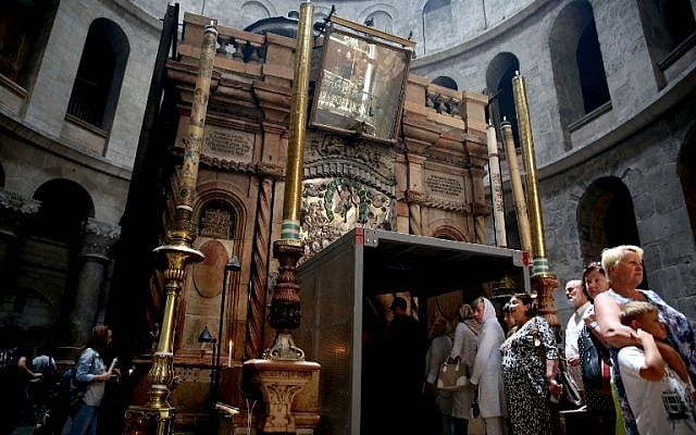 Tourists line up to enter the Tomb of Jesus as they stand under a metal scaffolding built at the entrance ahead of the restoration on May 29, 2016 at the Church of the Holy Sepulchre in Jerusalem's Old City. (AFP PHOTO / GALI TIBBON)
