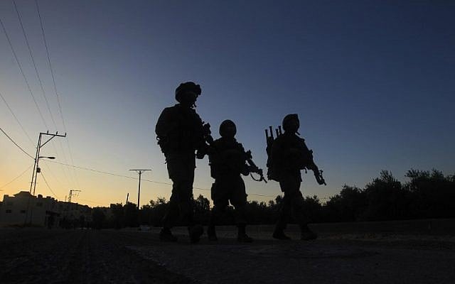 IDF soldiers patrol a street in the northern West Bank village of Salem, east of Nablus, during an operation to arrest wanted Palestinians early on May 30, 2016. (AFP/JAAFAR ASHTIYEH) IDF soldiers patrol a street in the northern West Bank village of Salem, east of Nablus, during an operation to arrest wanted Palestinians early on May 30, 2016. (AFP/JAAFAR ASHTIYEH)