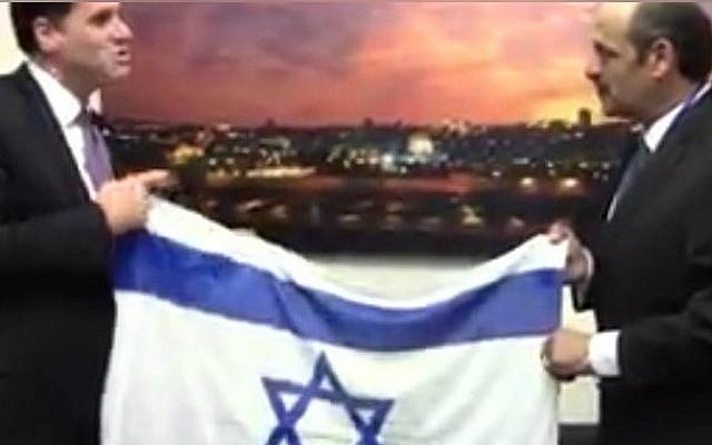 Hany Baransi proudly shows off this photo he keeps on his phone of his meeting with Israeli ambassador to the US Ron Dermer at the Israeli embassy in Washington, DC, March 2016. (Courtesy)