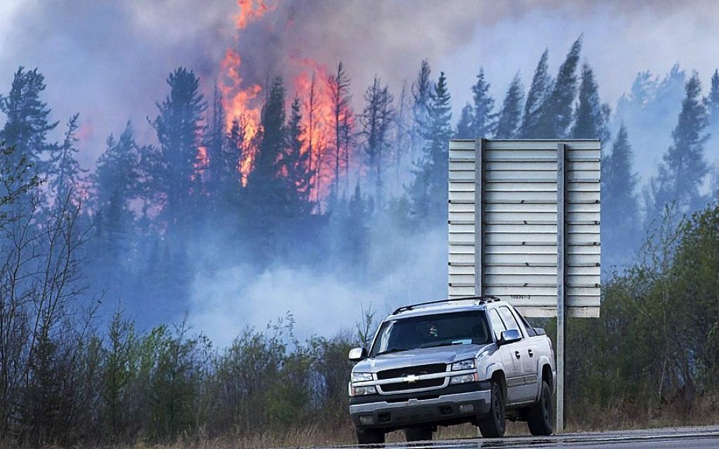 Flames flare up from hotspots from a wildfire along a highway to Fort McMurray, Alberta, Canada, Sunday, May 8, 2016. (Ryan Remiorz/The Canadian Press via AP) Flames flare up from hotspots from a wildfire along a highway to Fort McMurray, Alberta, Canada, Sunday, May 8, 2016. (Ryan Remiorz/The Canadian Press via AP)