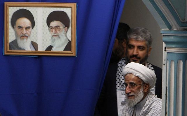 Ayatollah Ahmad Jannati arrives with Hamas chief Khaled Mashaal at a ceremony at Tehran university, Feb. 2, 2009. The picture frame features Iran's late leader Ayatollah Khomeini, left, and Iran's supreme leader Ayatollah Ali Khamenei. (AP photo/Hasan Sarbakhshian)