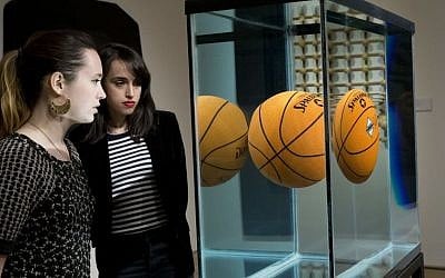In this Friday, April 29, 2016 photo, employees inspect "One Ball Total Equilibrium Tank" by Jeff Koons, on display during the press preview of "Bound to Fail" at Christie's auction house in New York. (AP/Mary Altaffer)