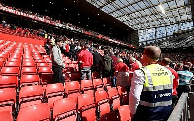 Fans leave the stands after a security announcement during the English Premier League match at Old Trafford, Manchester, England, May 15, 2016. (Martin Rickett/PA via AP)