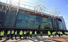 Security guards stand outside Old Trafford stadium after the final soccer match of the season between Manchester United and AFC Bournemouth was abandoned due to a suspect package being found inside the stadium on May 15, 2016. (Mike Egerton/PA via AP)