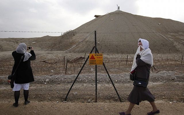 Greek Orthodox Christian pilgrims walk by a sign warning of mines as they take part in a traditional Epiphany baptism ceremony, at Qasr el Yahud on January 18, 2011. (Miriam Alster/Flash90)