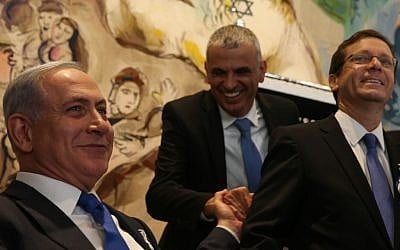 Prime Minister Benjamin Netanyahu (left) shakes hands with leader of the Kulanu party Moshe Kahlon (center) during the opening session of the 20th Knesset on March 31, 2015. At right is Zionist Union leader Isaac Herzog (Nati Shohat/Flash90)