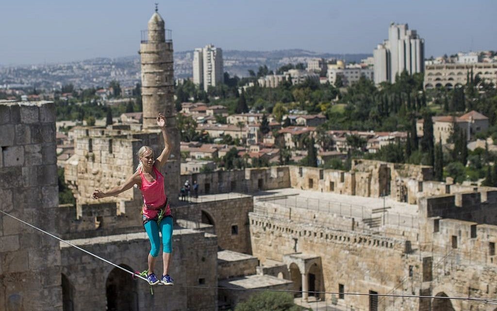 North American slackliner Heather Larsen walks on a cable above the David Tower Museum at the Jerusalem Old City Walls on May 2, 2016, (Yonatan Sindel/Flash90)