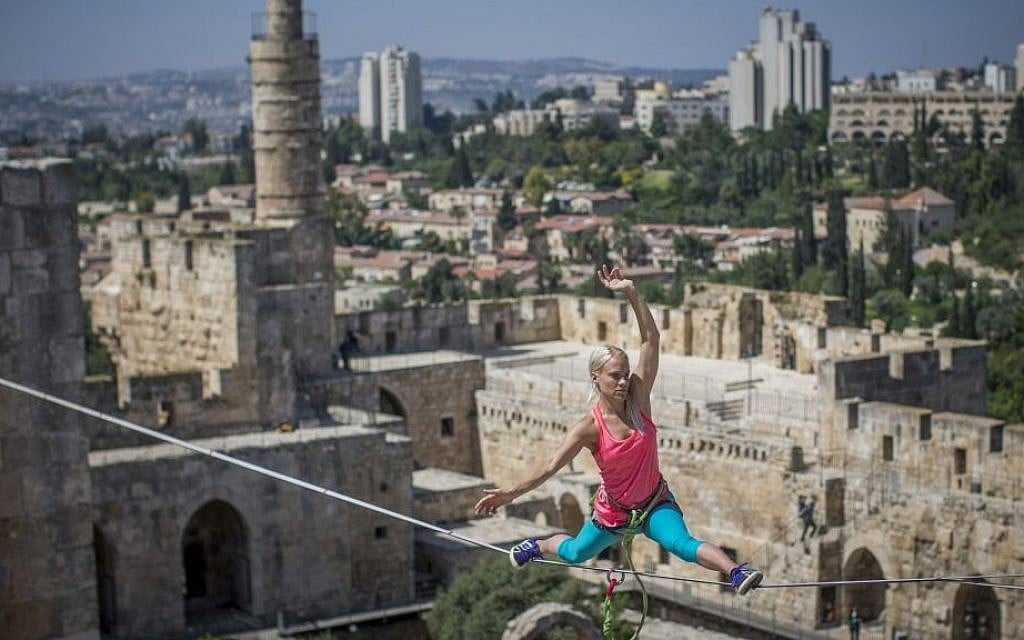 North American slackliner Heather Larsen walks on a cable above the David Tower Museum at the Jerusalem Old City Walls on May 2, 2016, (Yonatan Sindel/Flash90)