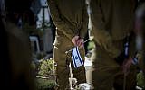 Israeli soldiers stand at attention during the flag laying ceremony -- held every year  a few days before Memorial Day for Israel's Fallen Soldiers -- at Mount Herzl Military Cemetery in Jerusalem, April 8, 2016. (Yonatan Sindel/Flash90)
