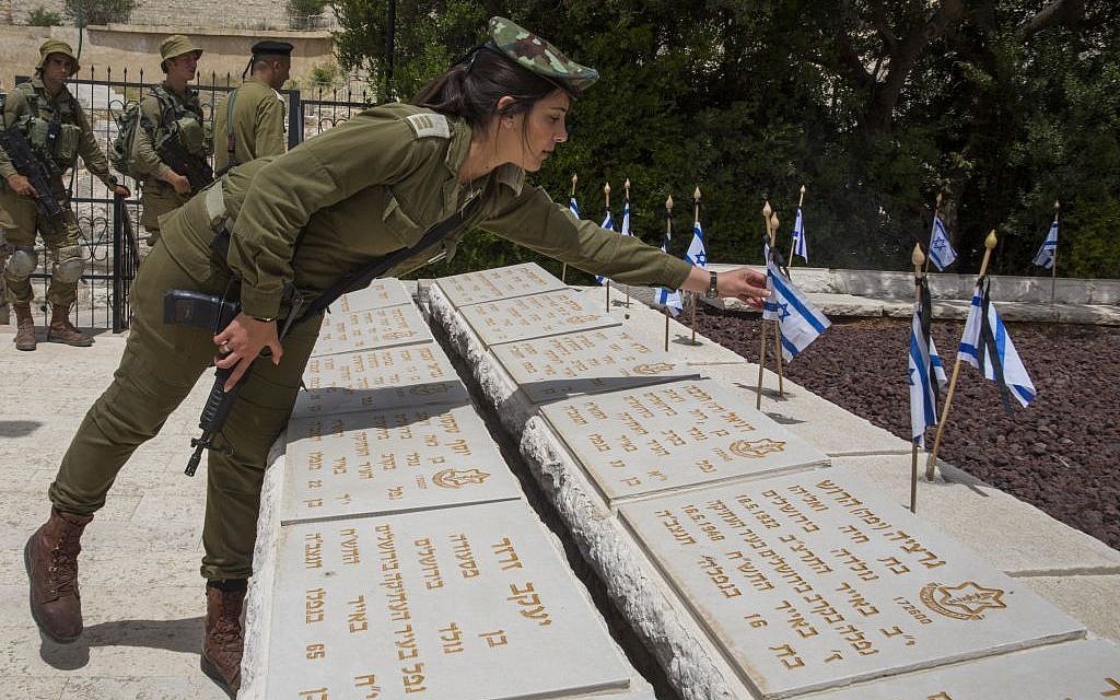 Israeli soldiers at Jerusalem's Mount of Olives military cemetery on May 10, 2016 place flags on the graves during a ceremony ahead of Memorial Day (Nati Shohat/Flash90) Israeli soldiers at Jerusalem's Mount of Olives military cemetery on May 10, 2016 place flags on the graves during a ceremony ahead of Memorial Day (Nati Shohat/Flash90)